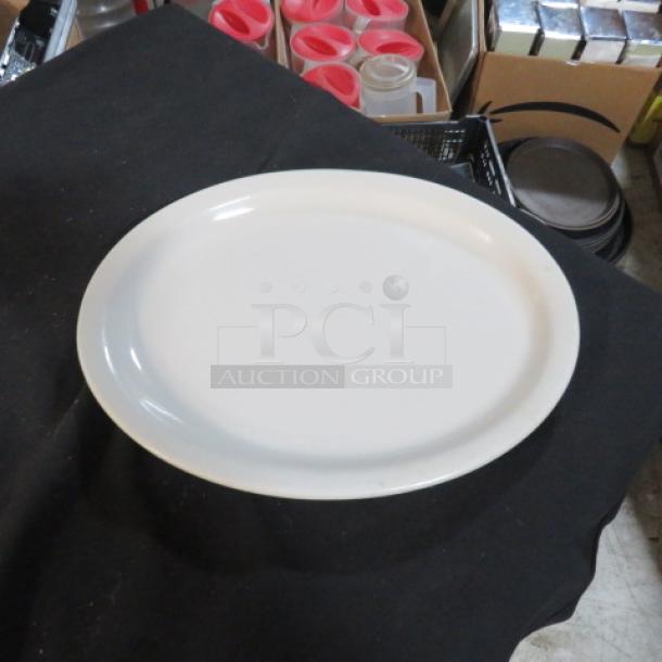 White oval platter, 13x10 inches, smooth finish, excellent condition, displayed on a black surface.