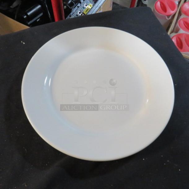 Plain 10-inch white plate in good condition, code 11XBID, on black surface.
