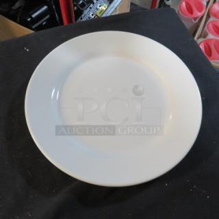 Plain 10-inch white plate in good condition, code 11XBID, on black surface.