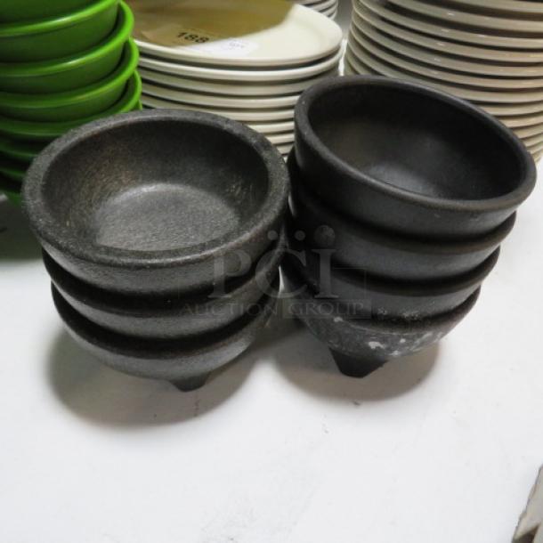 Stacked black salsa bowls, model 7XBID, textured finish, new condition, set among different colored plates.