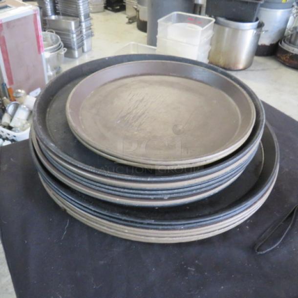 One lot of 15 assorted size waitress trays, stacked. Trays show signs of use, varying in diameter and finish.