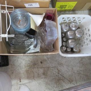 Box with assorted kitchenware items including glass jars, metal scoops, and containers. White basket with metal lids. Mixed condition.