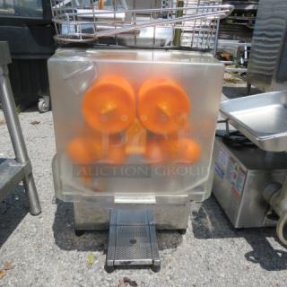 Commercial juicer model XC-2000E-2, 110V, features orange squeezing mechanism, stainless steel exterior, visible wear.