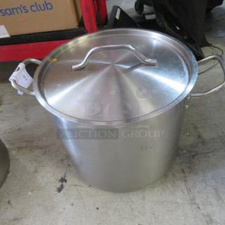 16 quart stainless steel stock pot with lid, featuring sturdy handles and a polished finish. Slightly used condition.