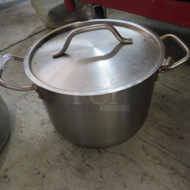 8-quart stainless steel stock pot with lid, featuring sturdy handles. Good condition, suitable for cooking large meals.