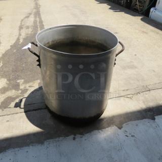 Large aluminum stock pot, 17x18 inches, with side handles; shows signs of use but in good condition for cooking or brewing.