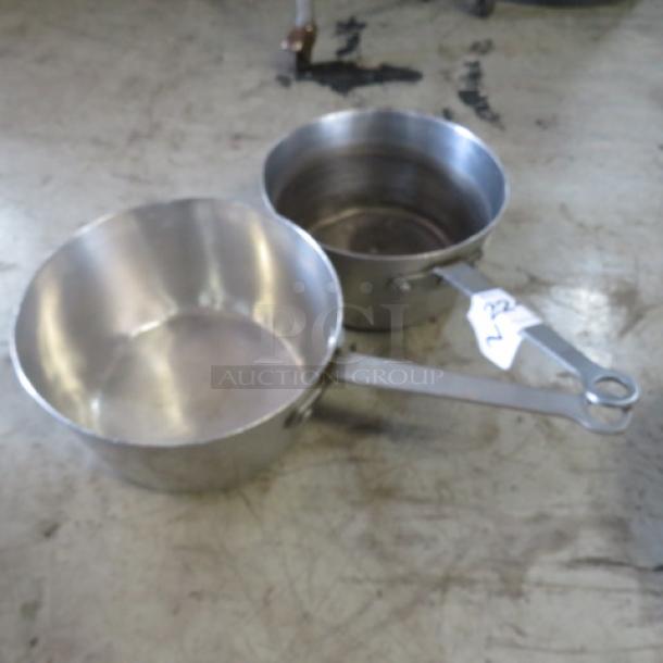 9-inch metal sauce pan in good condition, with attached tag labeled "2XBID". Sturdy handles, lightly worn surface.