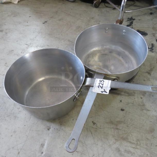 Two 12-inch aluminum saucepans with long handles, showing signs of wear. Label "225" attached to one handle.