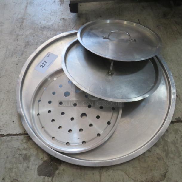 Assorted metal lids, including perforated and solid designs, in good condition. Label visible: "227."