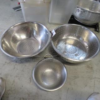 Assorted stainless steel colanders, 3 pieces; varying sizes, perforated for draining; excellent condition; includes handles.