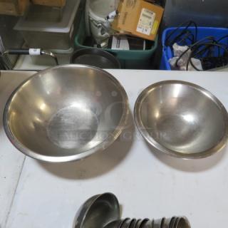Assorted stainless steel mixing bowls, various sizes, with a smooth finish. In good used condition.