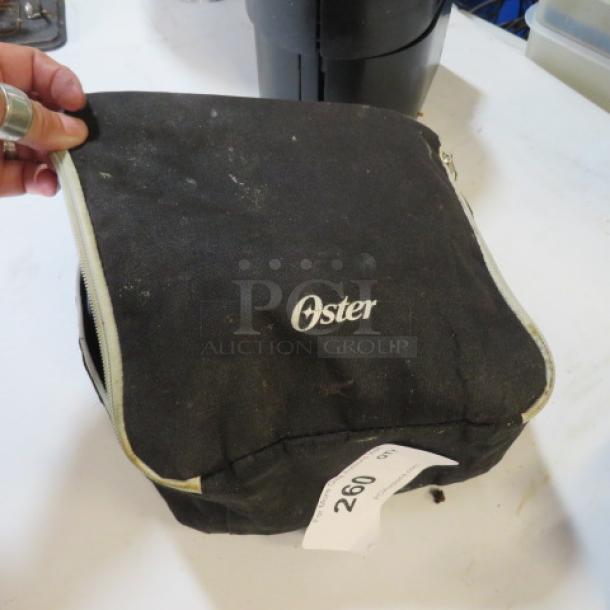 Black Oster carrying case for hand mixers, visible wear, zipper partially open, label reads "260."