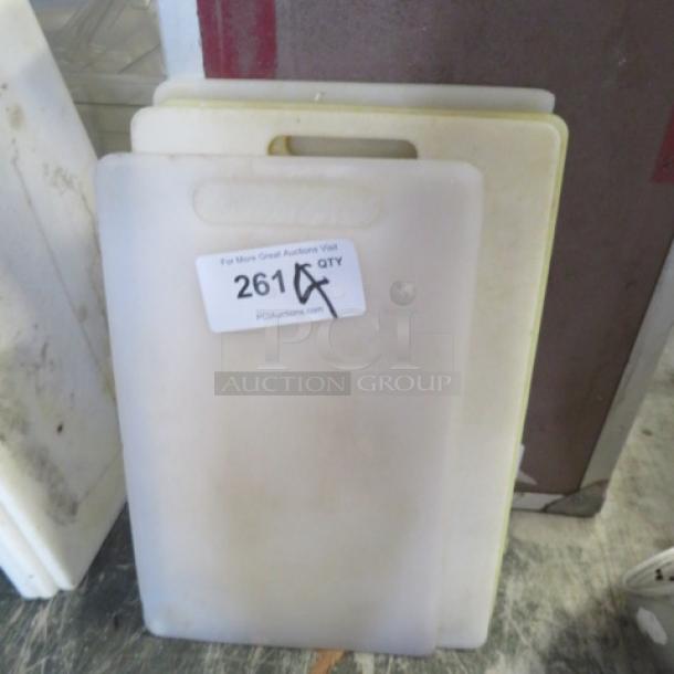 Assorted cutting boards, pre-owned, varying sizes, white and yellow, visible label: "261 QTY."