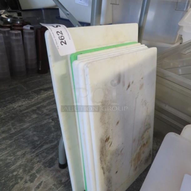 Assorted used cutting boards, various sizes. Visible wear and stains. Tag marked "202" attached. Suitable for kitchen use.