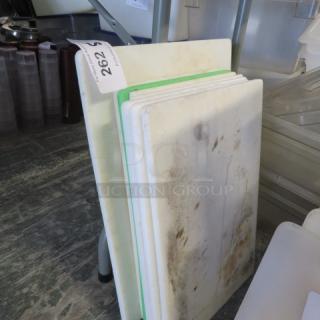 Assorted used cutting boards, various sizes. Visible wear and stains. Tag marked "202" attached. Suitable for kitchen use.