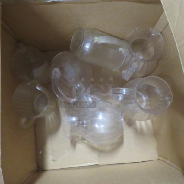 One lot of translucent poly pitchers in a cardboard box, various sizes and designs, in good condition. Great for versatile use.