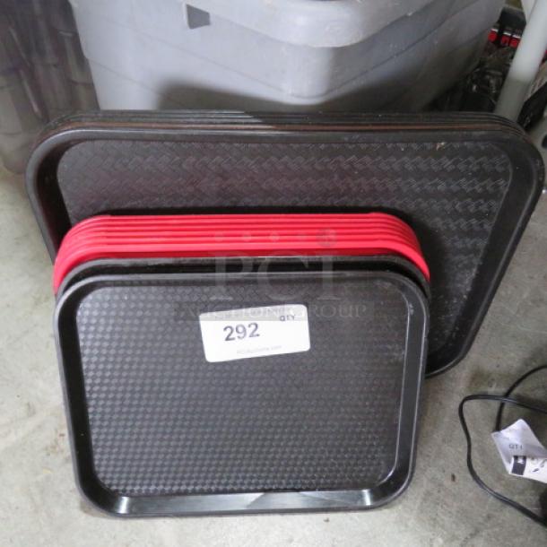 Assorted lunch trays in black and red, stacked. Includes textured surfaces. Marked with lot number 292 for auction.