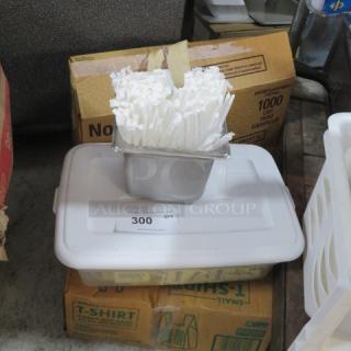 Box containing miscellaneous items, including a metal container with white straws, placed on a plastic lid. Quantity tag shows "300."