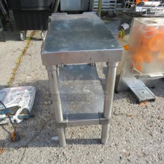Stainless steel table with undershelf, 12x24x24 inches, weathered condition, ideal for industrial use.