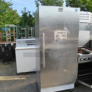 Kelvinator commercial freezer, Model KFS220RHY2, stainless steel, 32x31x74.5 inches, 115V, with four racks on casters.