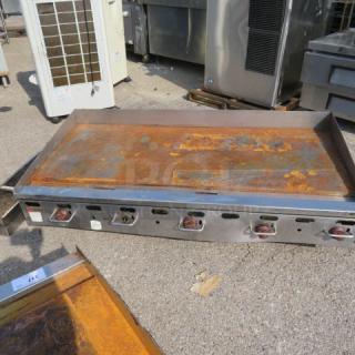 Wolf Natural Gas Griddle, Model AGM60-101, 60"x32"x18", rusted surface, five control knobs, priced at $6900.