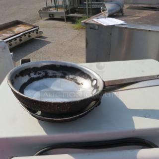 9-inch iron skillet with worn surface and long handle. Visible rust marks. Suitable for cooking or collector's item.
