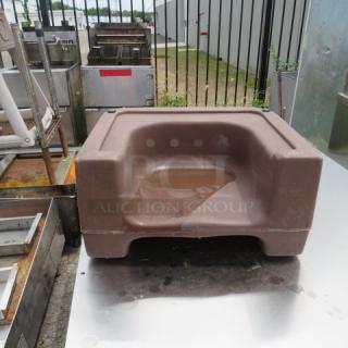 Brown Cambro booster seat, used condition, with molded seat and armrests. Suitable for dining areas.