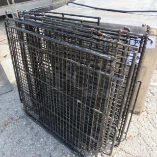 Assorted metal racks, black, stacked. Dimensions 26.5x24 inches. Used condition; suitable for storage or shelving.
