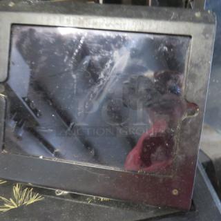 Black iPad on a stand, model #A2602. Screen has visible smudges. Housed in a protective case.