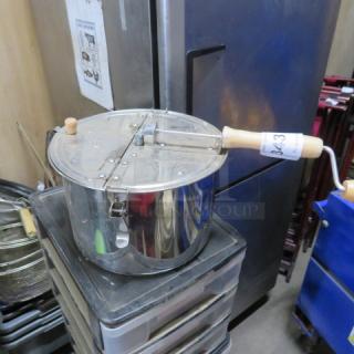 Lindys popcorn popper with hand crank, metal body, wooden handle, and lid. Used condition, slight surface wear visible.