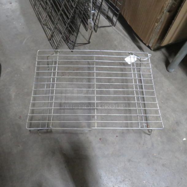 One lot of 19 metal cooling racks, various sizes, stackable design, used condition, suitable for commercial kitchens.