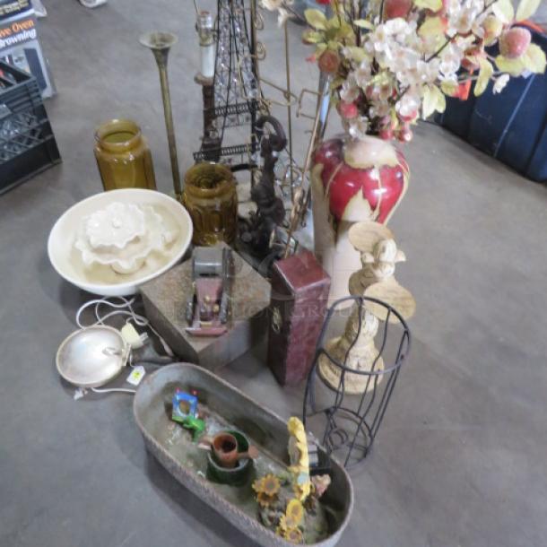 Miscellaneous decorative items, including vases, metal sculptures, a floral arrangement, and trays. Mixed materials and conditions.