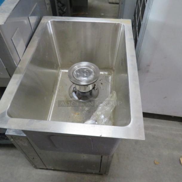 New stainless steel drop-in sink, 12x15x9.5 inches, with visible drain assembly, in excellent unused condition.