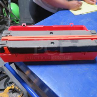 Red plastic case with triangle flares inside, featuring secure slots and red latches, on a blue table.