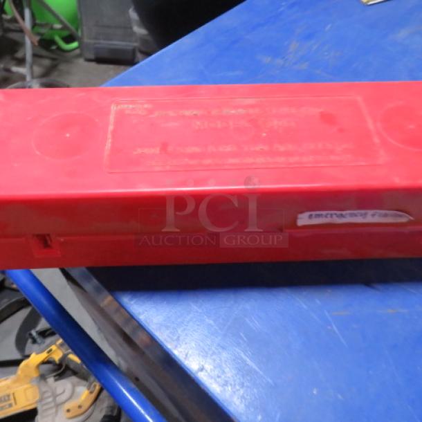 Red plastic case containing emergency roadside triangle flares. Rectangular shape with label indicating content. Good condition.