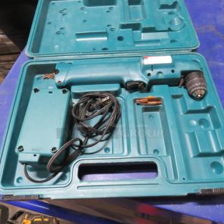 Makita cordless angle drill DA391A in carry case with charger. Drill shows light wear. Case has molded compartments for storage.