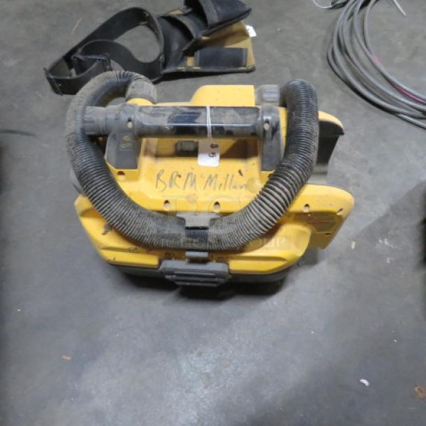 Yellow Dewalt shop vac, compact design, flex hose, signs of wear, "B.R. McMillan" written on top, used condition.