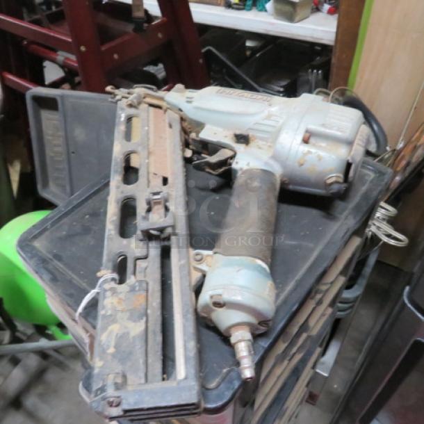 Hitachi nail gun in used condition, showing signs of wear. Features a metallic body with visible brand markings.