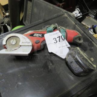 Skil Saw #889, handheld, red and black, visible wear. Includes a tag marked "370." Cordless with a detachable battery.