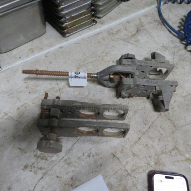 Lot of miscellaneous metal clamps; visible wear, rust, and markings. Includes screws and adjustment knobs.