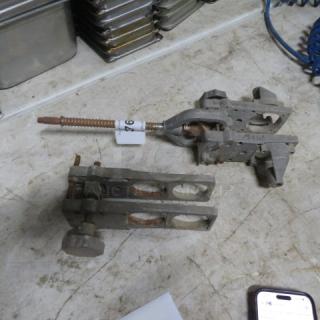 Lot of miscellaneous metal clamps; visible wear, rust, and markings. Includes screws and adjustment knobs.