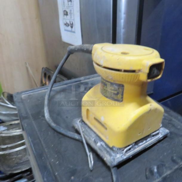 Stanley Palm Sander DW411, yellow, used condition, visible wear. Power cord attached.
