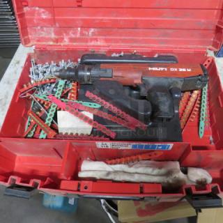 Hilti DX36M fastening tool in red carry case, includes nails and accessory strips. Good condition with visible Hilti branding.