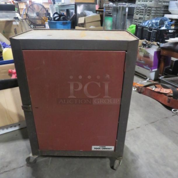 Metal tool cabinet on casters with a red front door. Features a sturdy build and visible wear. Label reads "Tool Cabinet."