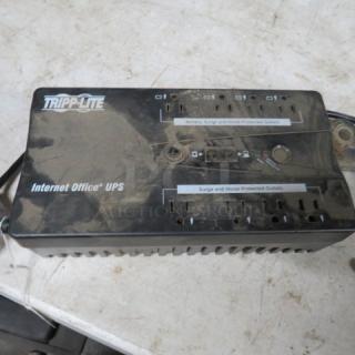 Tripp Lite Battery Backup, black, multiple outlets, marked "Internet Office UPS," visible wear and dust.