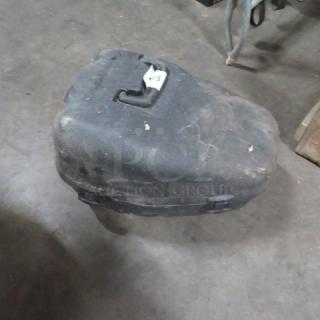 Black plastic chain saw case, scuffed and used condition, with a latch and visible handle on top. White paper tag labeled "45".