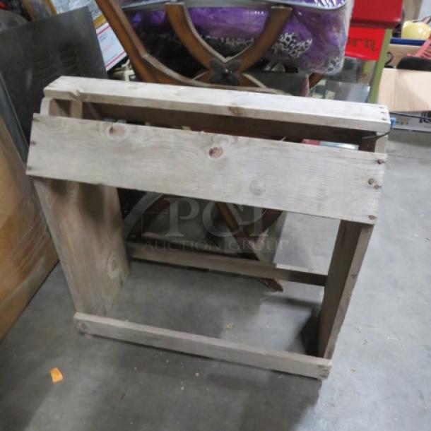 Wooden saddle stand in rustic condition, rectangular frame, natural wood finish, visible wood grain. Suitable for stable use.