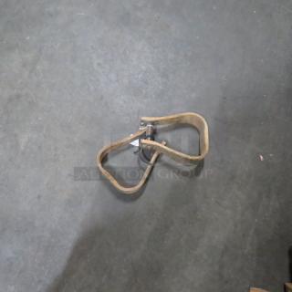 Set of wooden stirrups on concrete floor, showing wear. No visible tags or markings. Stirrups are loop-shaped.