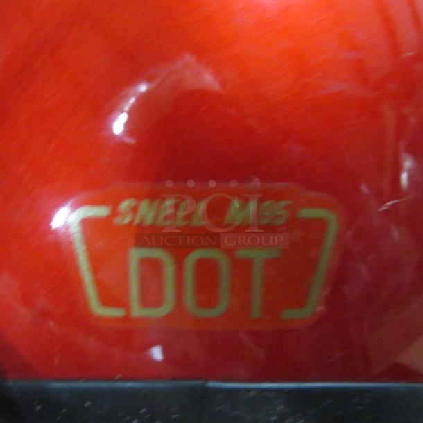 Red motorcycle helmet with DOT and Snell M95 markings. Includes protective bag and extra shields.