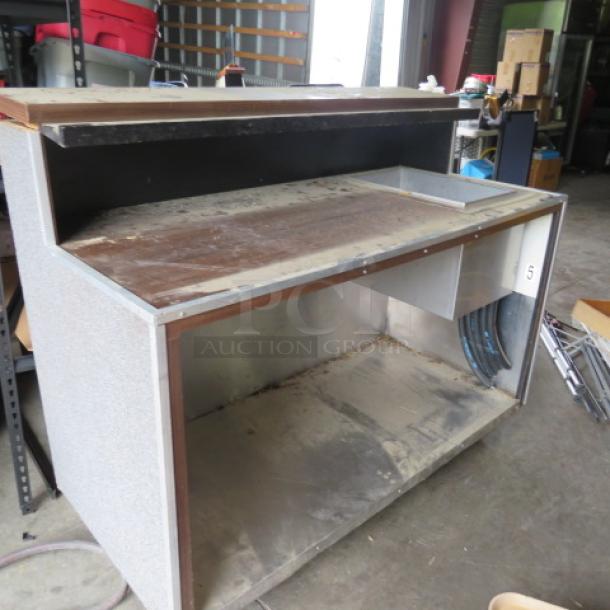 Portable bar with cold well, 61x28x50 inches. Features 12x19x10.5 cold well, under shelf, on casters. Used condition.
